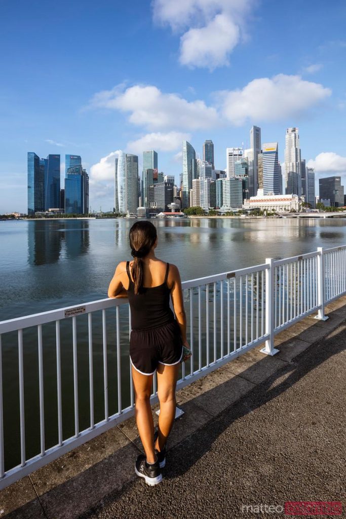A woman traveler admires the modern singapore skyline.