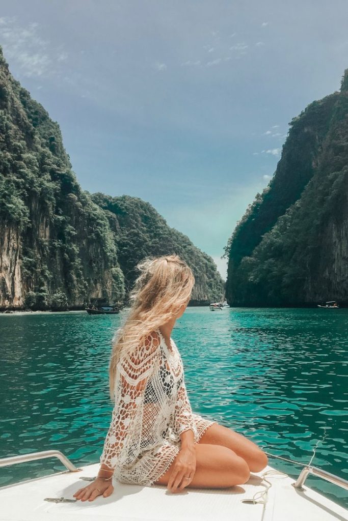 Idyllic Phi Phi Islands' turquoise waters and towering cliffs, where a woman traveler finds serenity amidst paradise.