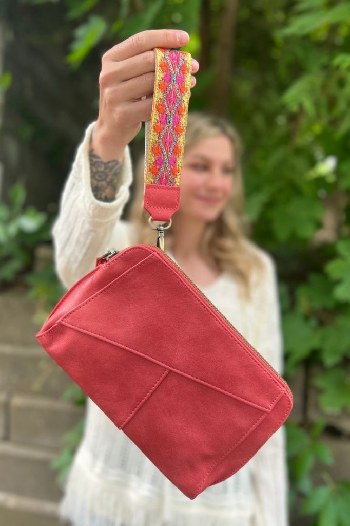 Compact wristlet with a sleek design and a convenient wrist strap.