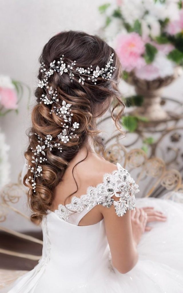 Elegant messy braided hair adorned with intricate floral accessories, perfect for a romantic bridal look.